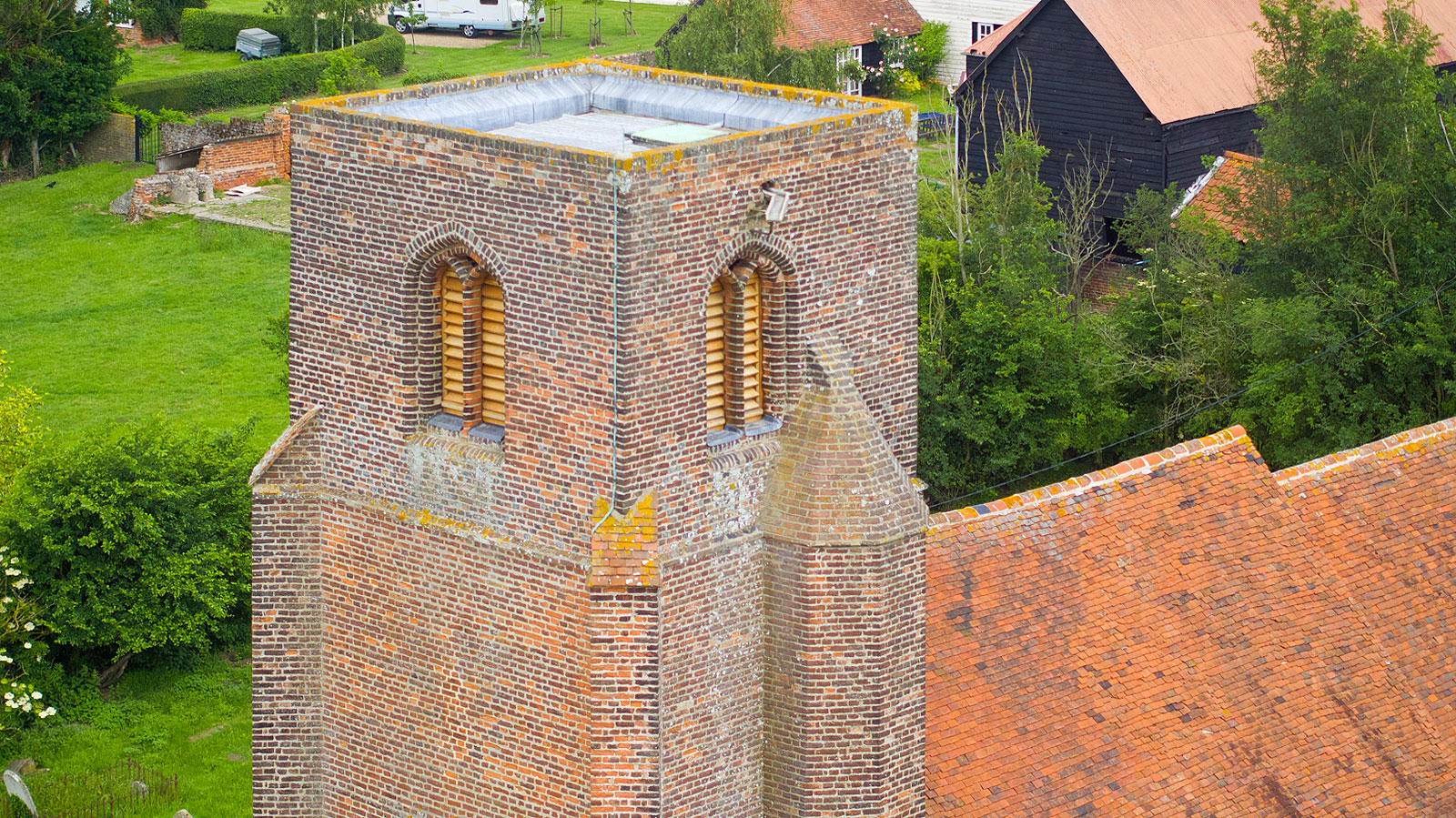 Aerial photograph of an historic church in Essex showing a close up view of the tower