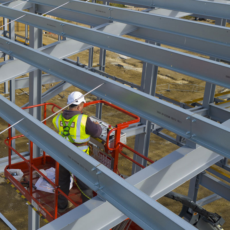 Photo of workers erecting steel skeleton of large building