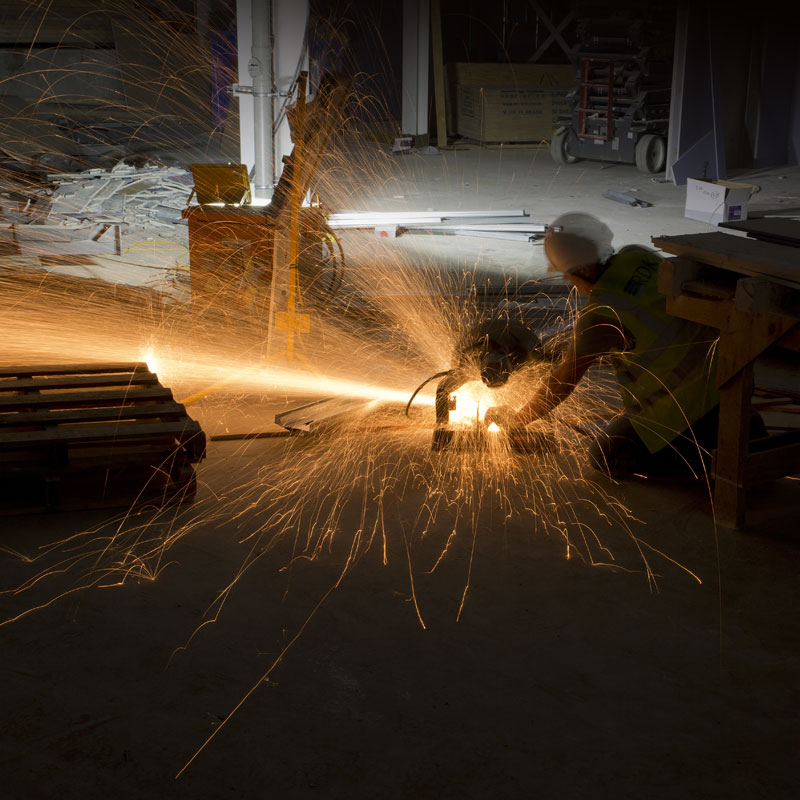 Photography of construction worker cutting steel
